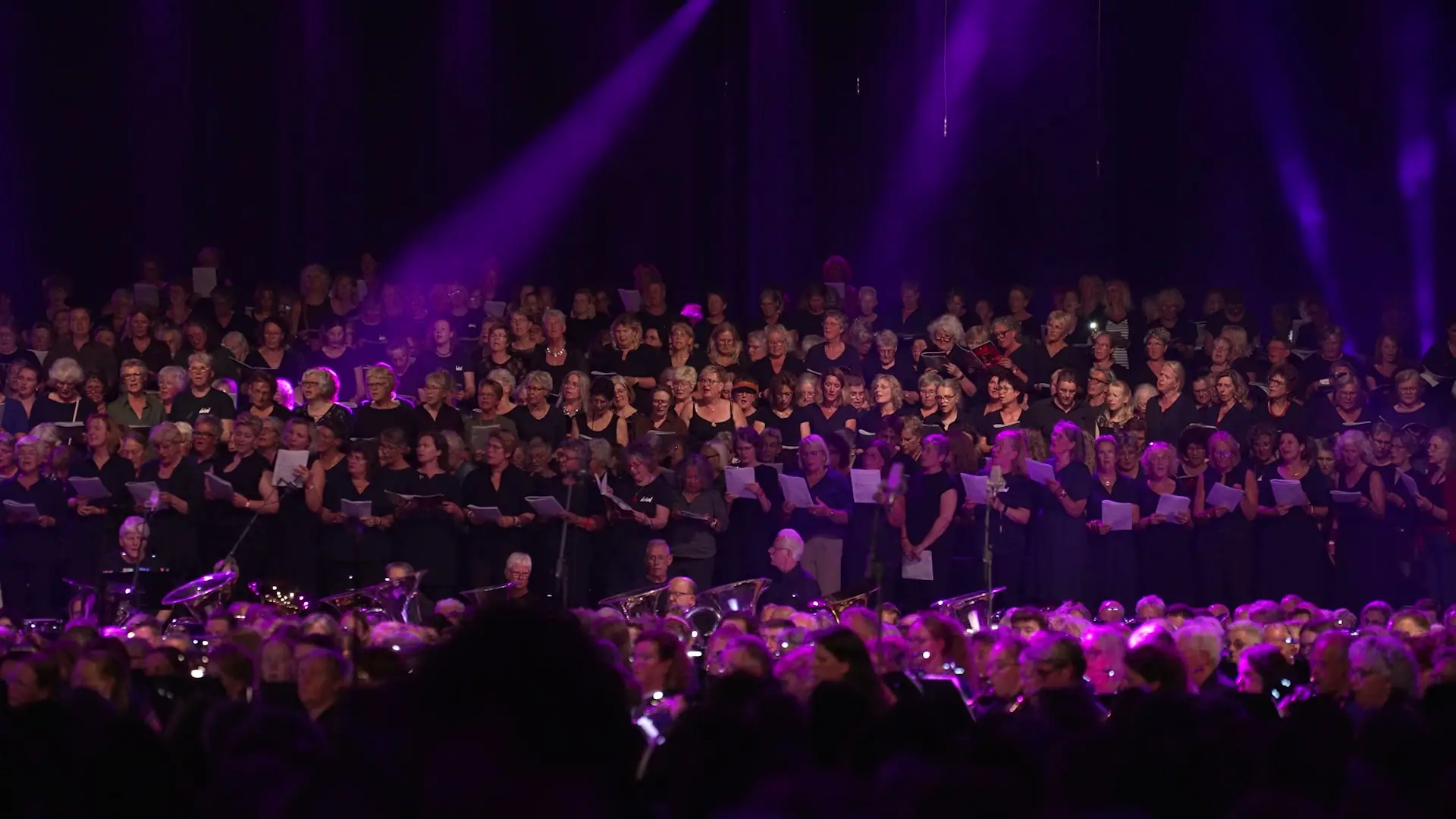 Koor en orkest in paars licht tijdens LÛD 2026