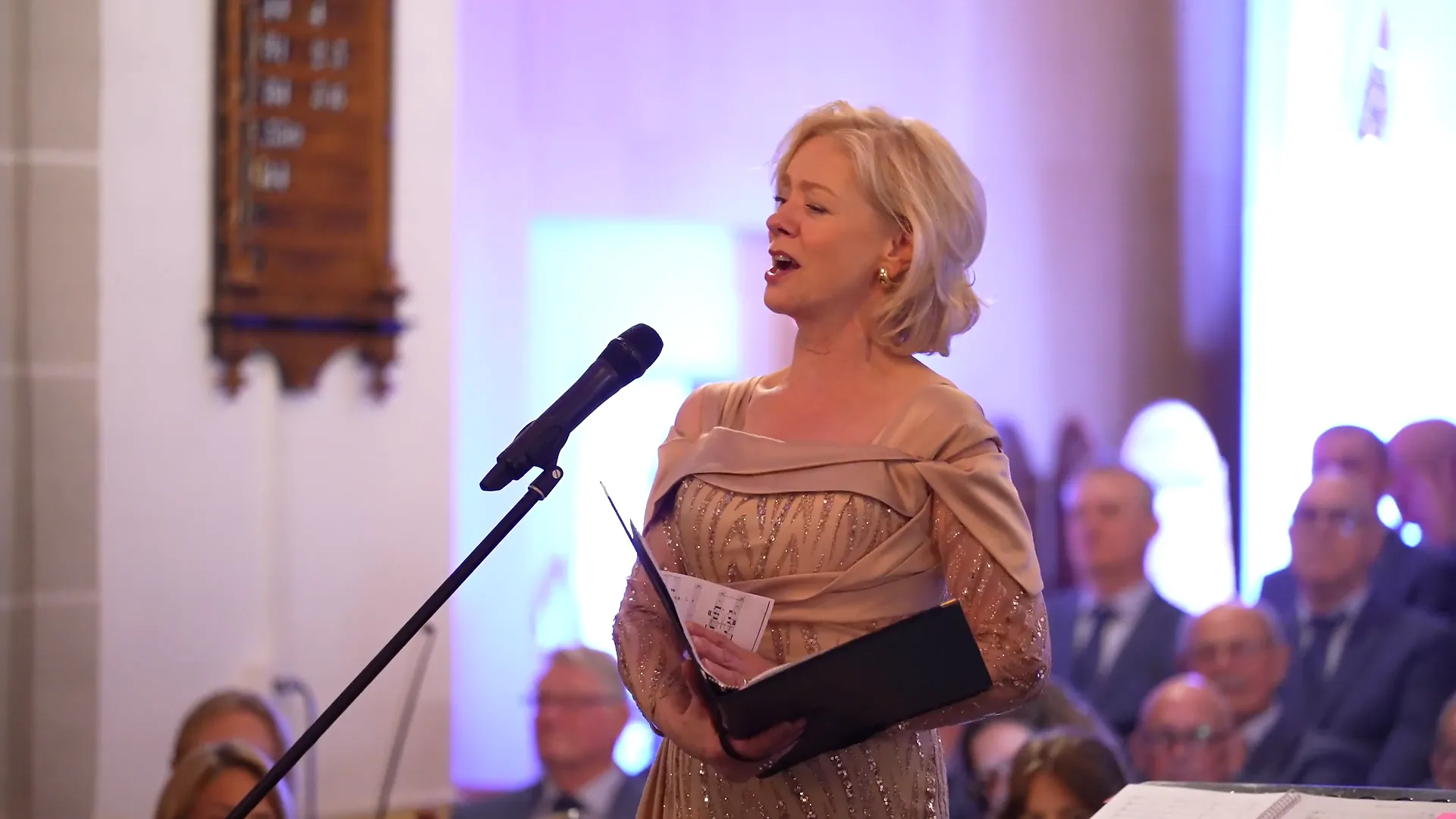 Een sopraan zingt haar solo, met het koor op de achtergrond