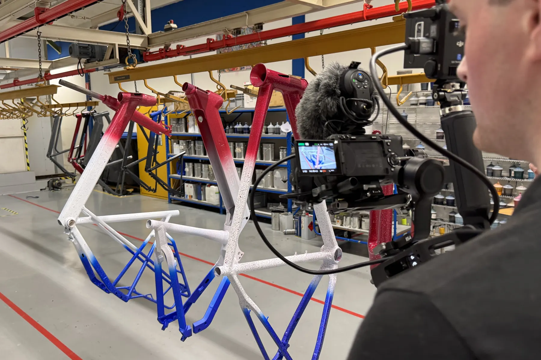 Camera op een gimbal filmt fietsframes in de spuiterij van de fietsenfabriek in Heerenveen