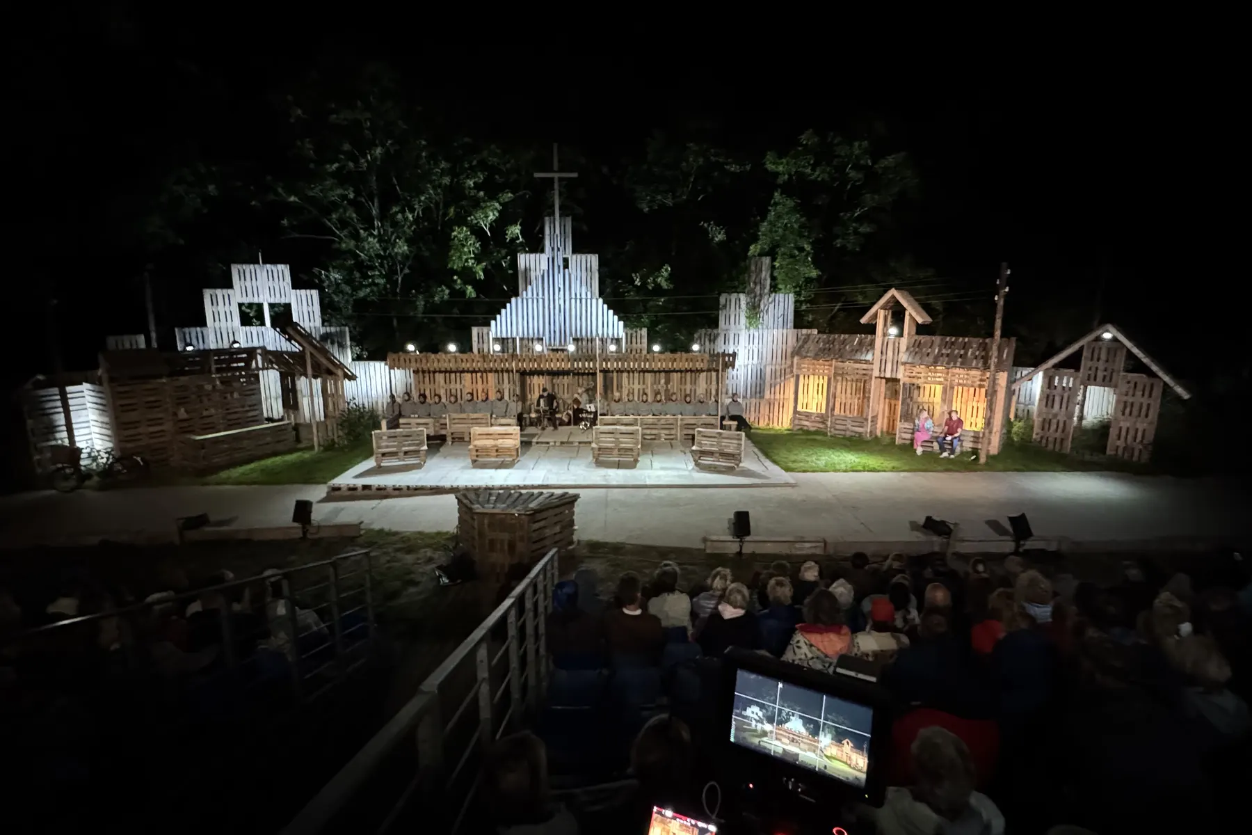 Camera en monitoren tijdens de opname van een openluchtvoorstelling bij avond