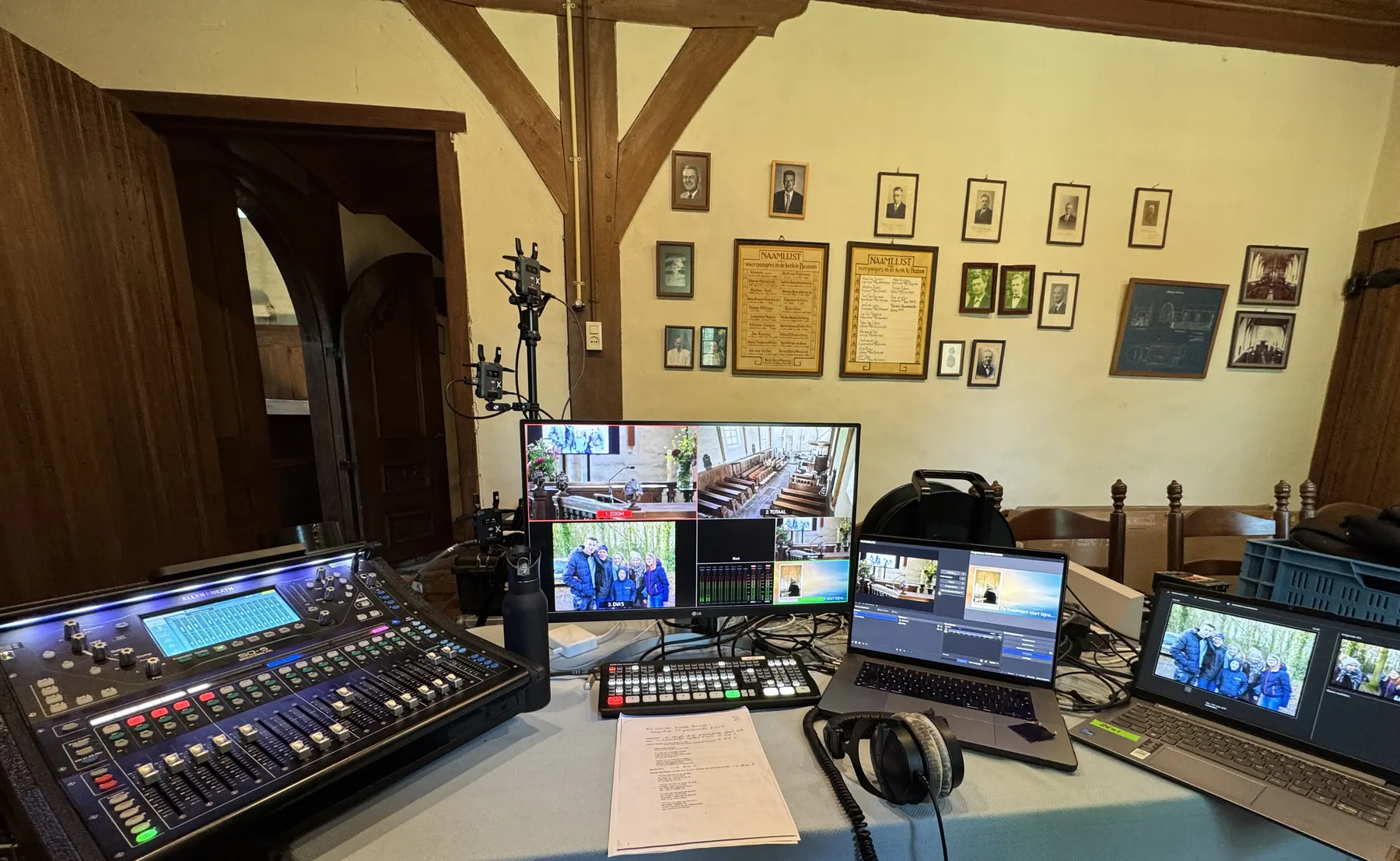 Regieplek met mengtafel, monitoren en laptops achter in een kerk